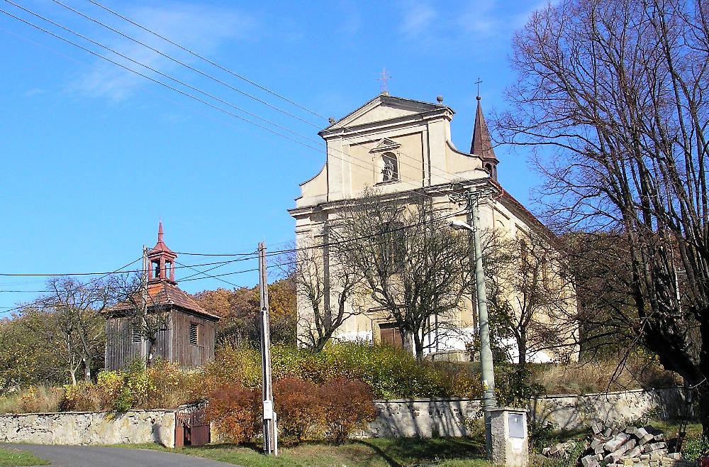 Sutom � kostel sv. Petra a Pavla s vedle stoj�c� d�ev�nou zvonic�.