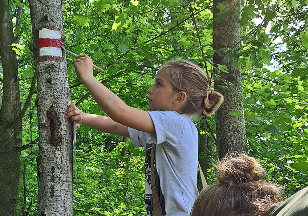 Skautka maluje novou turistickou zna�ku.